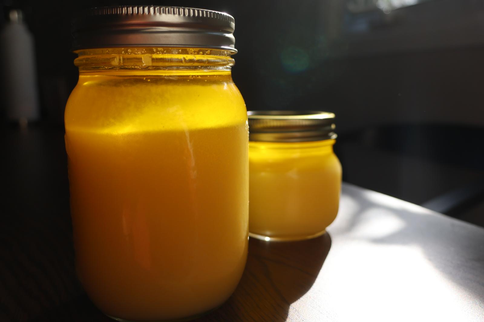 Sunlight shining through a fresh jar of golden ghee.
